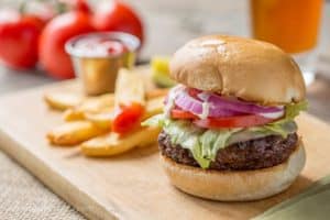 Marinated burger and french fries on cutting board