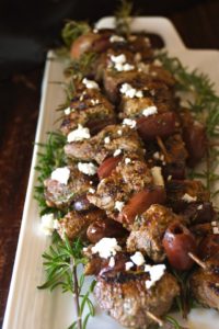 Grilled rosemary lamb kebabs on tray