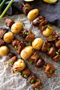 Four steak and potato kebabs on parchment paper