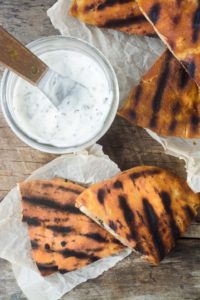 Spiced lamb pita burgers and sauce on parchment paper