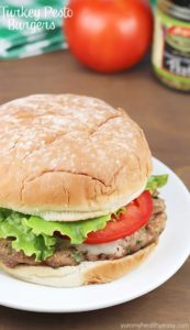 Turkey pesto burger topped with lettuce and tomato on plate