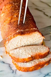 Easy smoked pork loin being sliced on marble counter