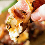Hand holding bacon wrapped jalapeno popper