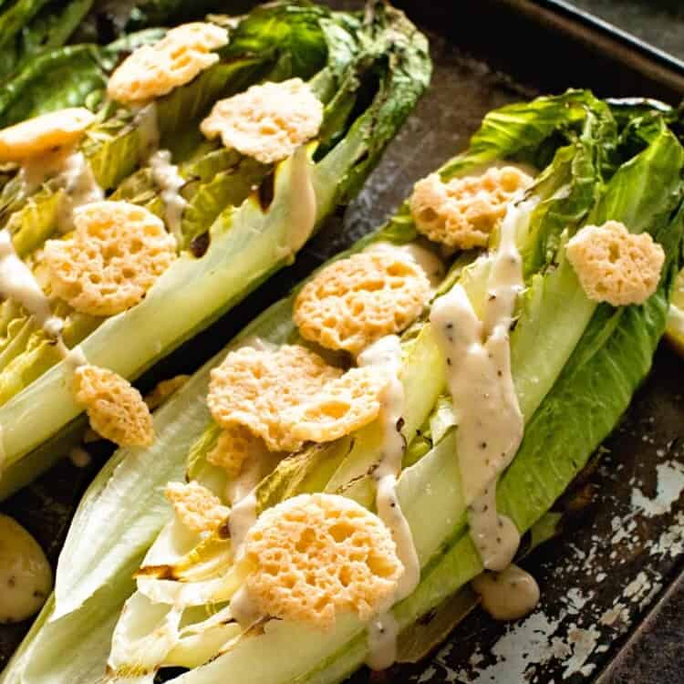 Grilled Caesar Salad with dressing on baking sheet