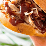 Pulled pork sandwich with barbecue sauce in hand