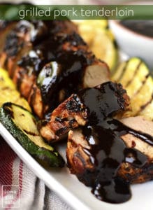Grilled pork tenderloin slices with sauce and grilled zucchini on plate