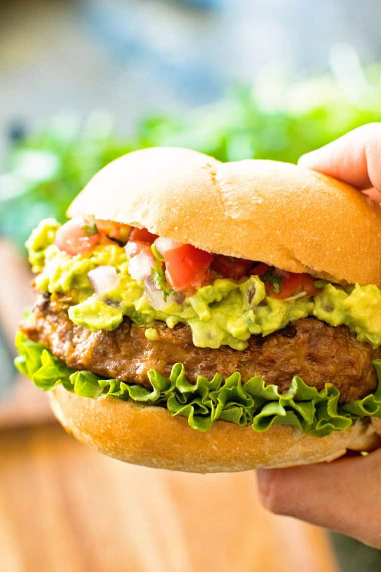 A hand holding a taco burger.