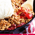 Strawberry Crisp. A cast iron skillet filled with baked strawberries with a crispy topping and a scoop of ice cream.