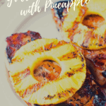 Grilled pork chops with pineapple on white plate