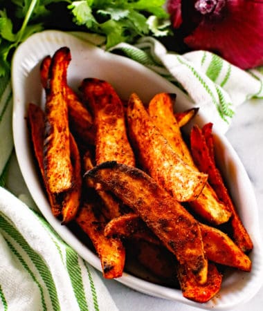 Seasoned sweet potato wedges in white bowl