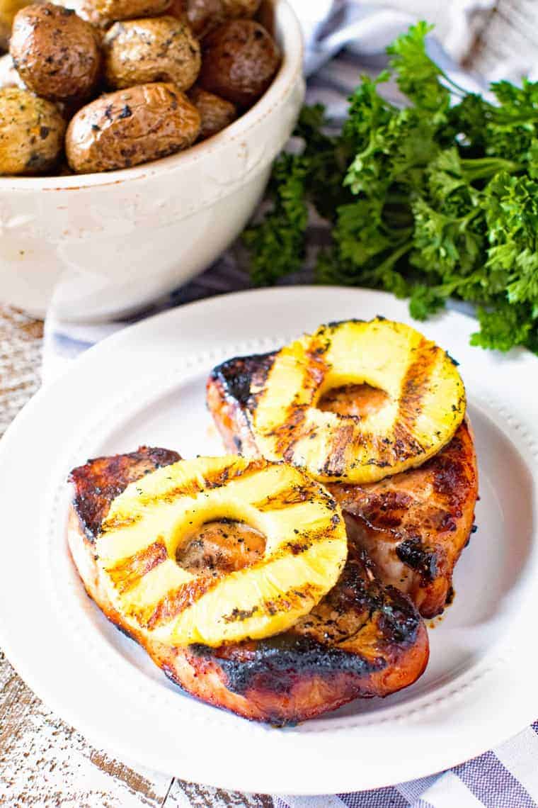 Pork chops with grilled pineaple on a white plate