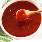 Sweet and Sassy BBQ Sauce in white bowl with wood spoon