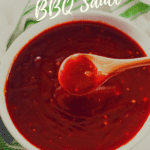 Sweet and Sassy BBQ Sauce in white bowl with a wood spoon
