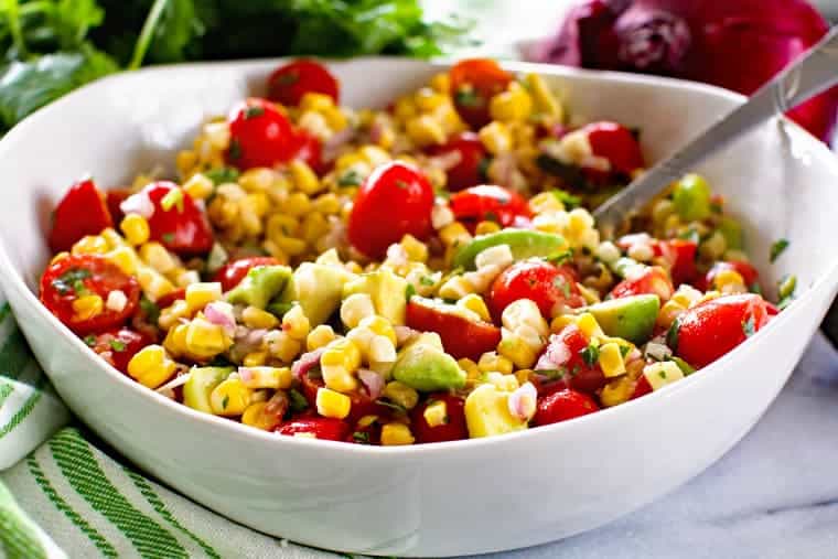 Grilled Corn Salad in white bowl wiht spoon in it