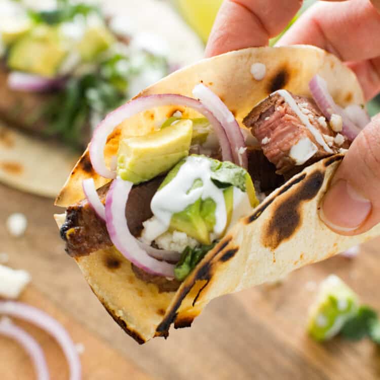 Hand holding chile lime steak taco