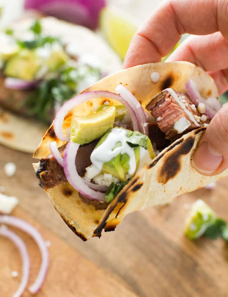 Hand holding chile lime steak taco