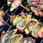 Bacon wrapped brussels sprouts on skewers on the grill.