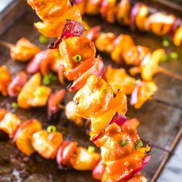 Hand holding a Grilled Buffalo Chicken skewer