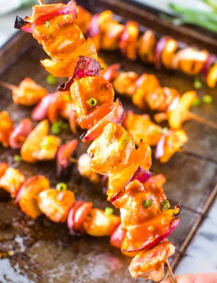 Hand holding a Grilled Buffalo Chicken skewer