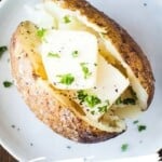 Smoked baked potato with butter on plate