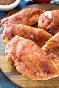 Dry rubbed smoked chicken breasts on a cutting board