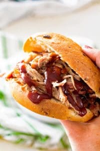 Smoked cider brined pulled pork sandwich in hand