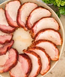 A plate with slices of smoked pork loin in a circle.