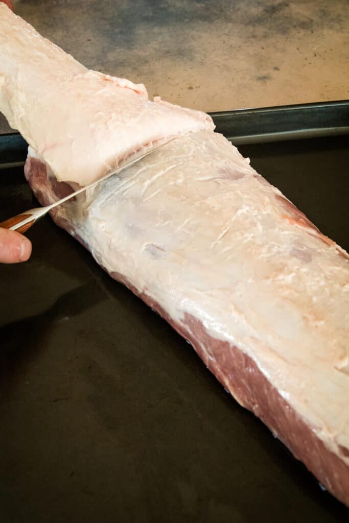 Cutting fat cap off of a pork loin