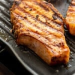 Pork chop marinade pinterest image. Pork chops being grilled on a griddle.