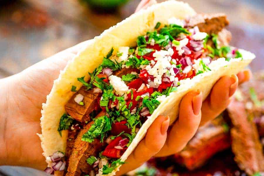 Hand holding Flank Steak Tacos