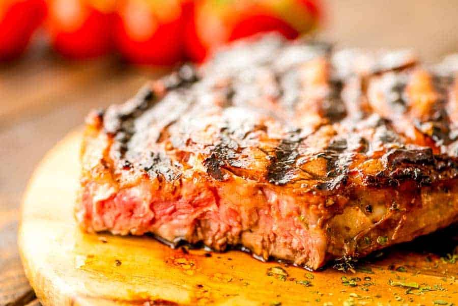 Cut grilled Italian dressing steak on board