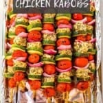 Greek chicken kabobs in a foil lined pan