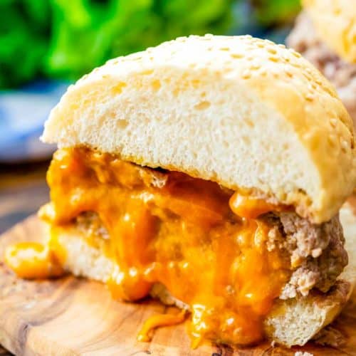 Juicy Lucy burger cut in half on a wood plank