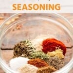 Chicken seasoning unmixed in a glass bowl.