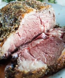 Grilled prime rib sliced on a white serving tray.