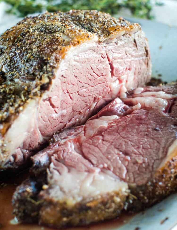 Grilled prime rib sliced on a white serving tray.