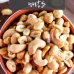 Smoked nuts mix in a white and red bowl.