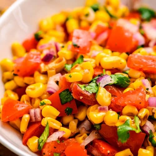 Bowl with grilled corn tomatoes onions and lime dressing