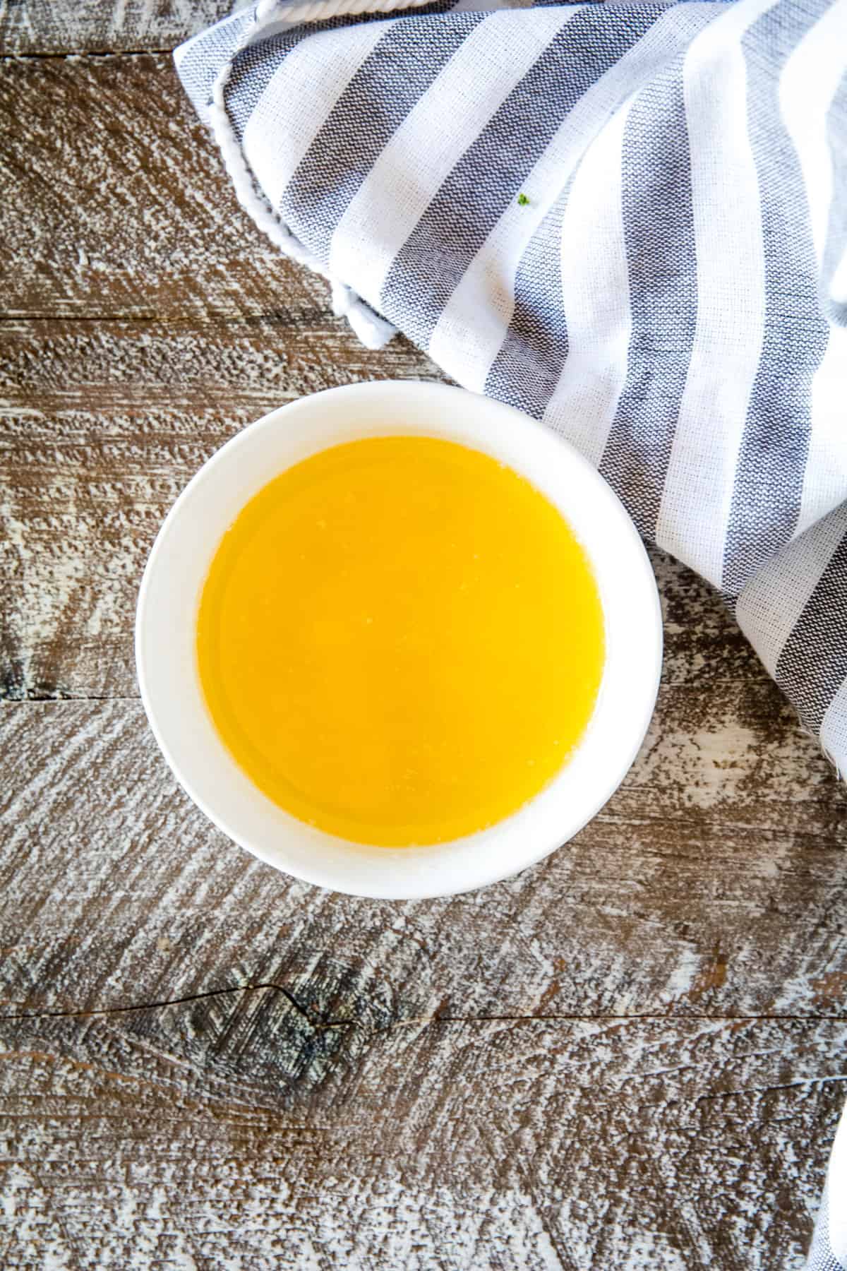 White bowl with melted butter in it.