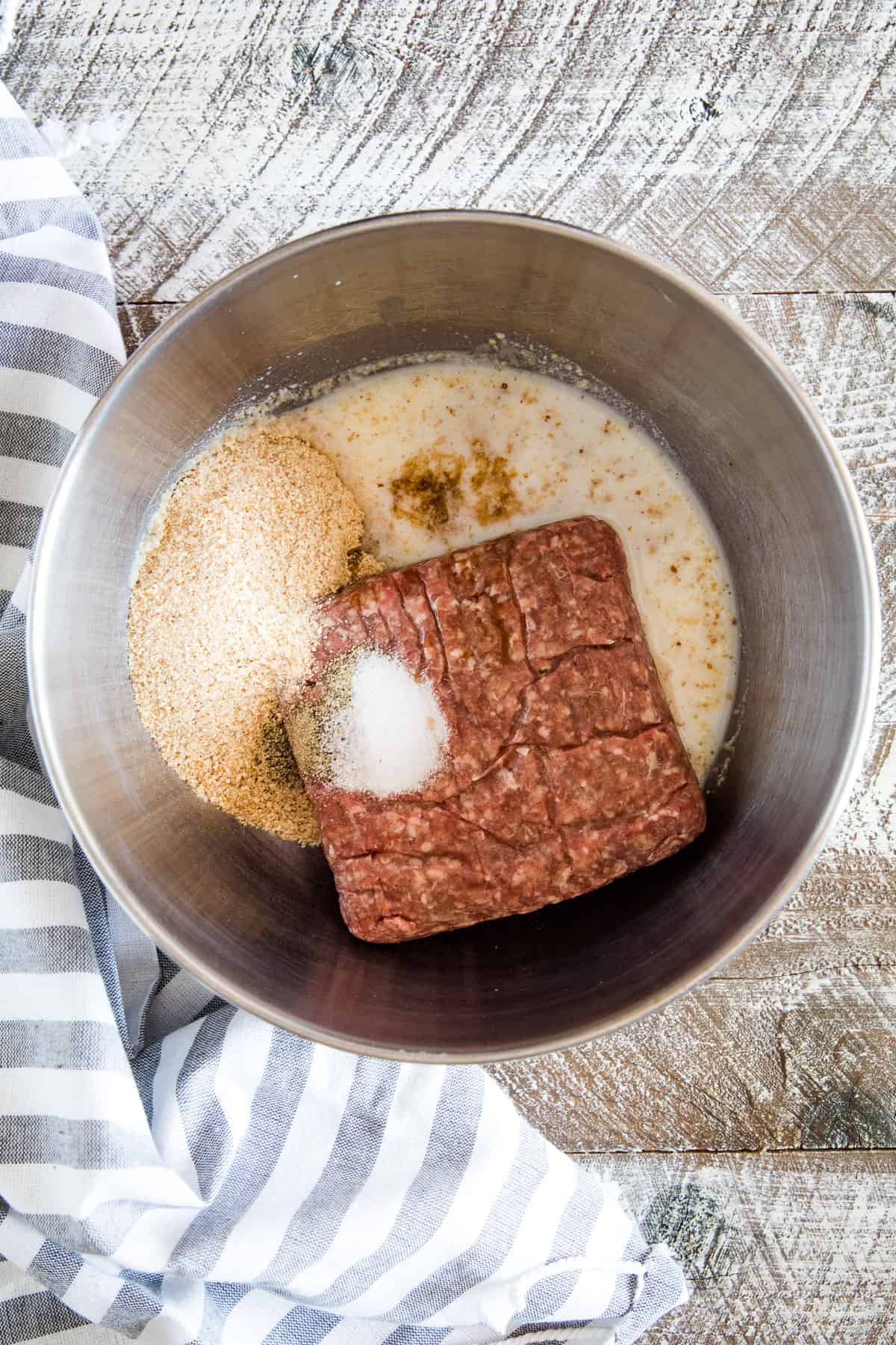 Tin bowl with ground hamburger, milk, bread crumbs and seasonings for smoked meatballs