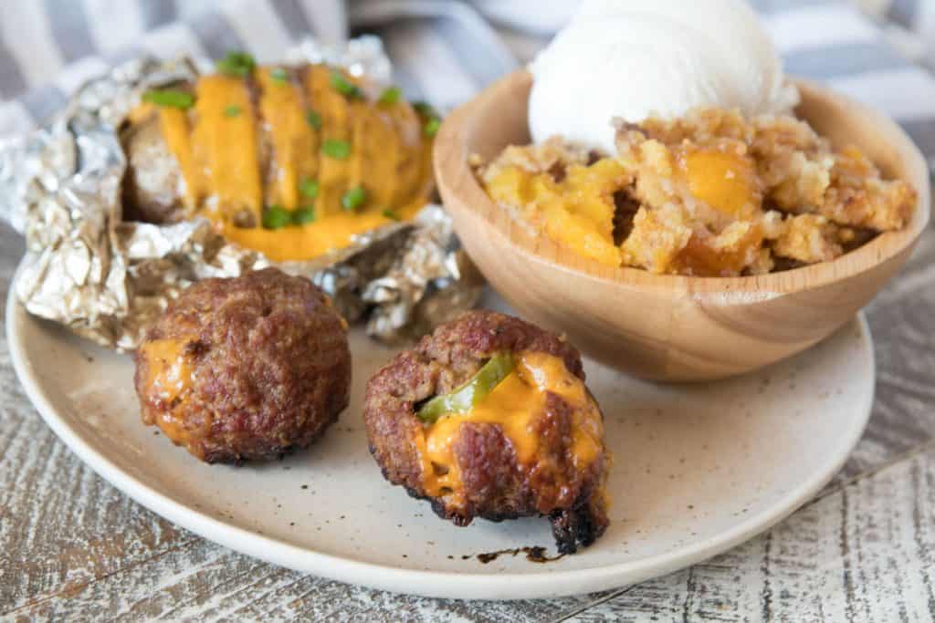 Image showing jalapeno meatballs, hasselback potatoes and peach dump cake on plate
