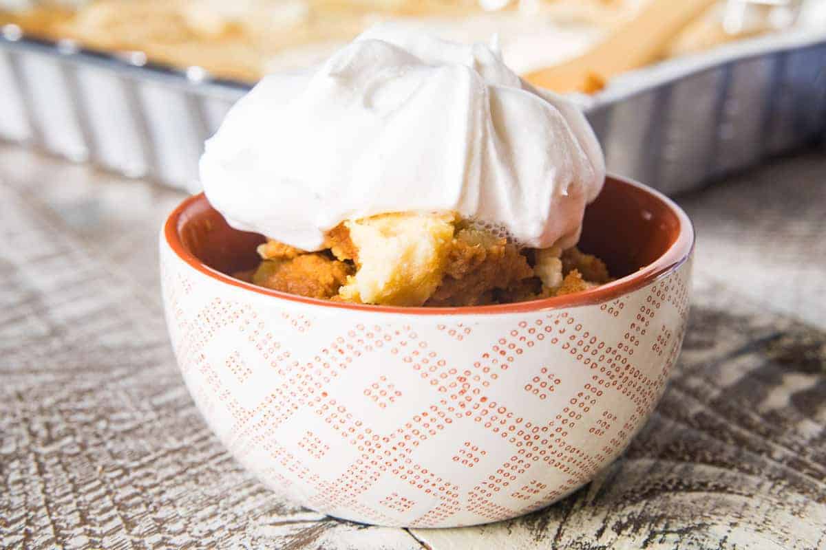 Bowl with pumpkin dump cake topped with Cool Whip