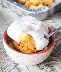Smoked Pumpkin Dump Cake in bowl topped with cool whip