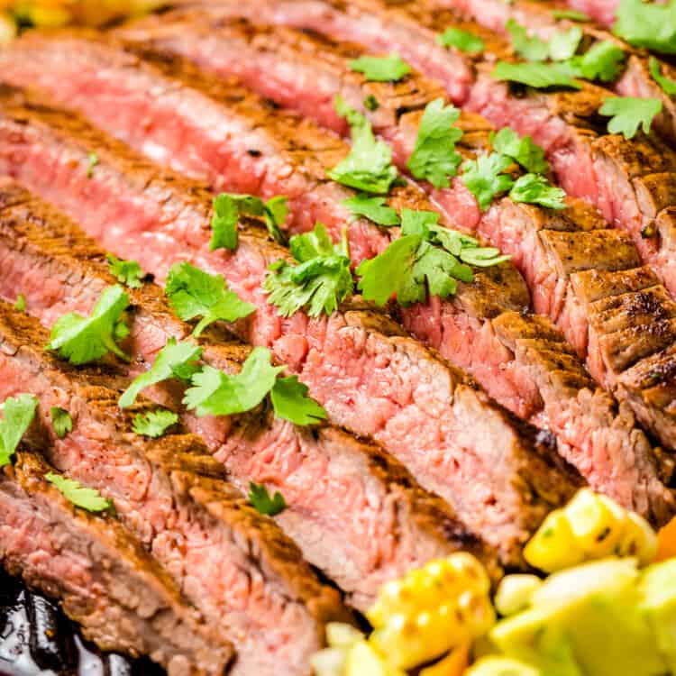 Sliced Grilled Flank Steak topped with chopped parsley and corn salsa