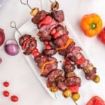 Overhead image of smoked steak kabobs on white plate