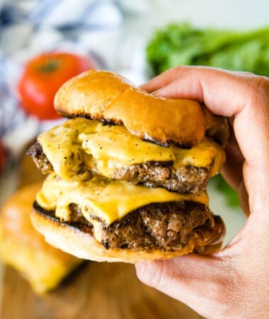 Hand holding double smash burger