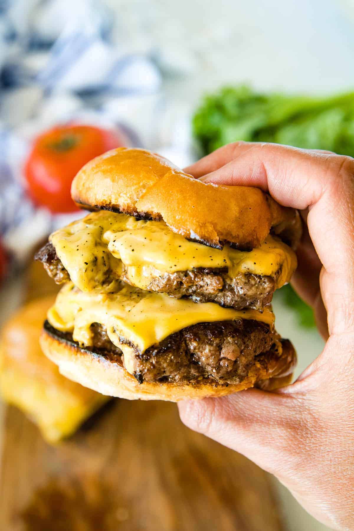Hand holding double smash burger