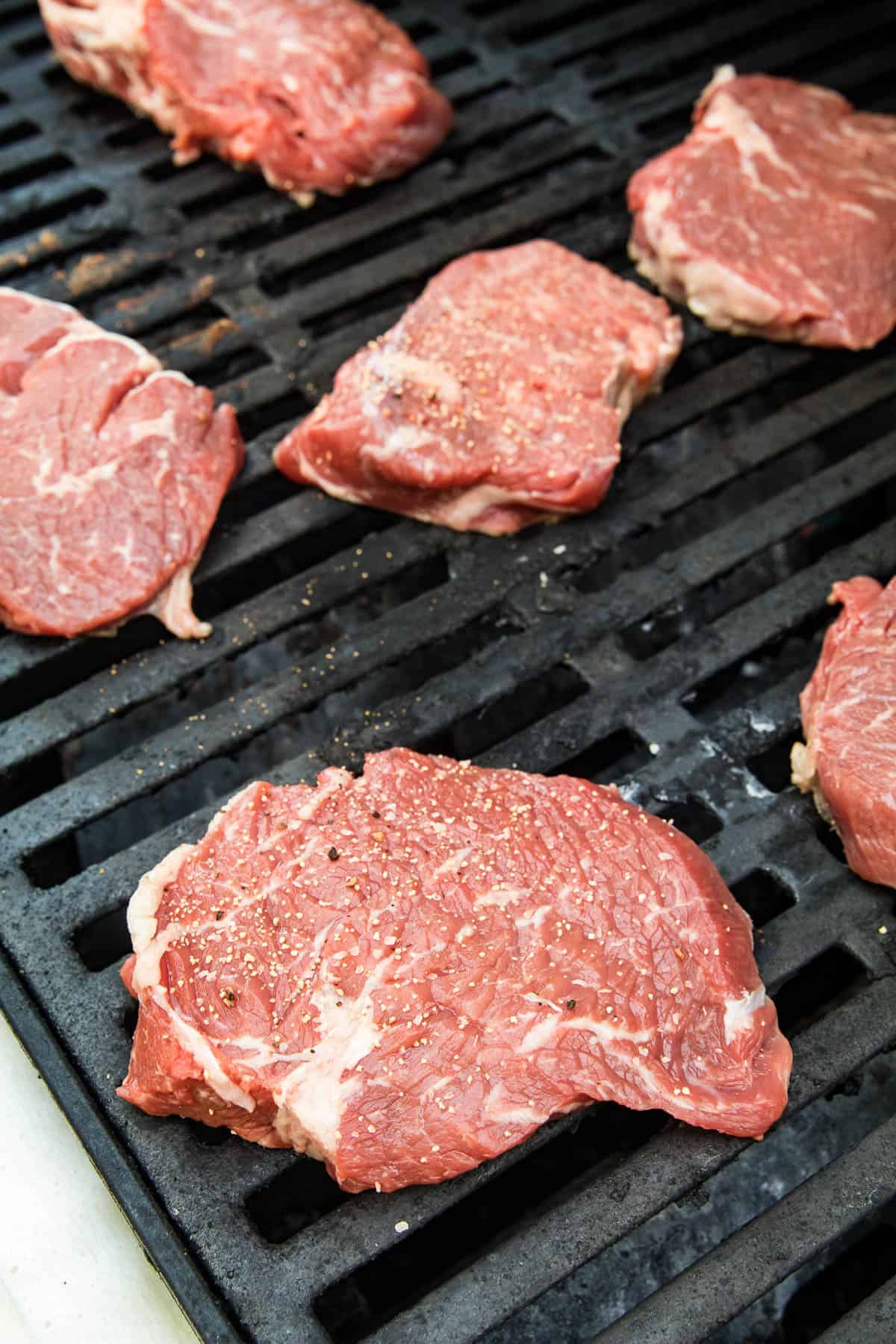 Raw ribeye steak on grill