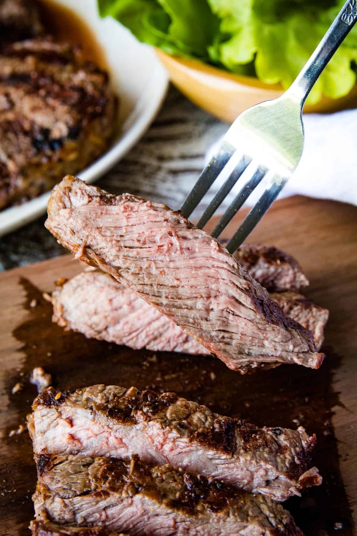 Fork holding piece of ribeye steak