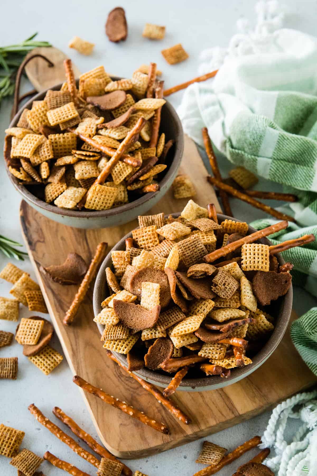 Bowls of chex mix on wood cutting board